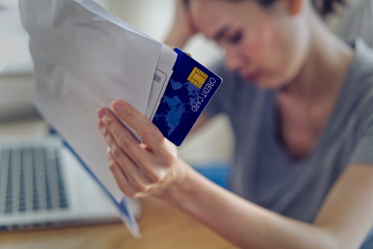 Asian woman hands holding credit card and bills worry about find money to pay credit card debt