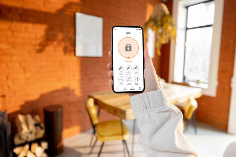 Woman holding phone with running smart home security application